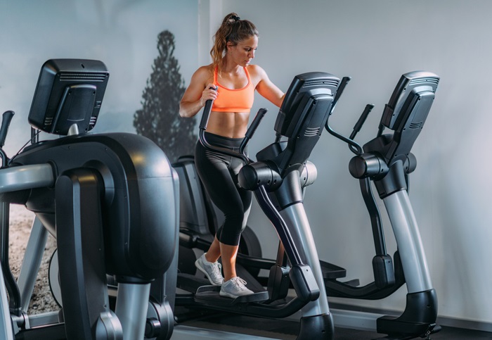 En tjej som kör intervaller på en crosstrainer